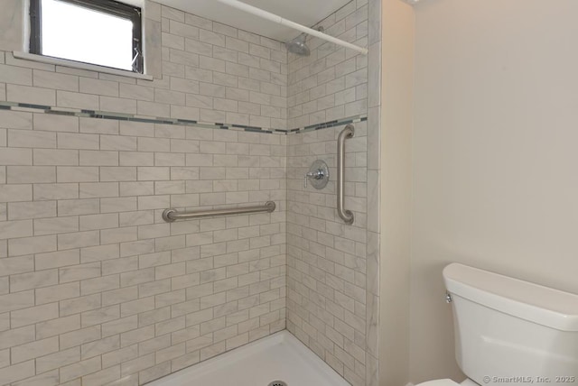 bathroom with toilet and a tile shower