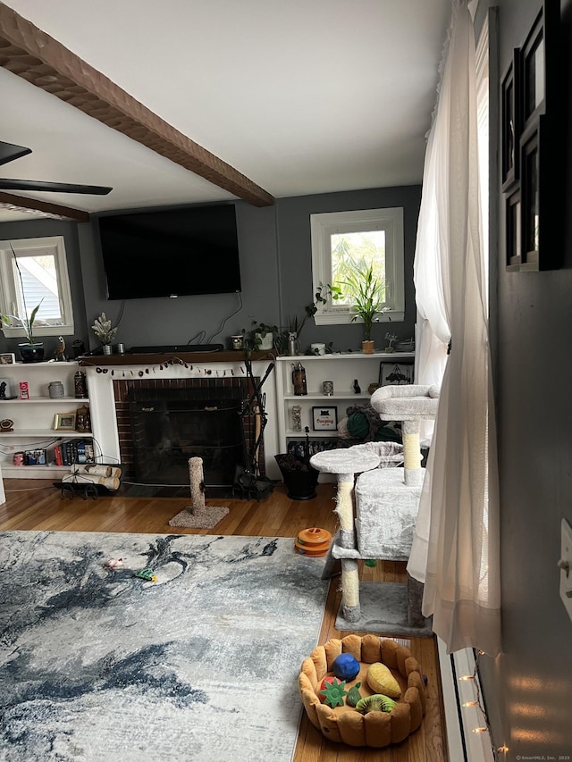 living room with hardwood / wood-style flooring, ceiling fan, and beam ceiling