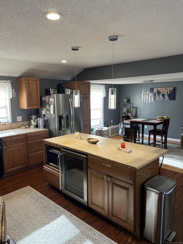 kitchen featuring wine cooler, decorative light fixtures, a textured ceiling, and appliances with stainless steel finishes