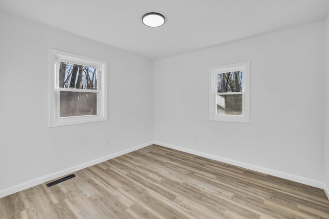 empty room featuring plenty of natural light and light hardwood / wood-style flooring