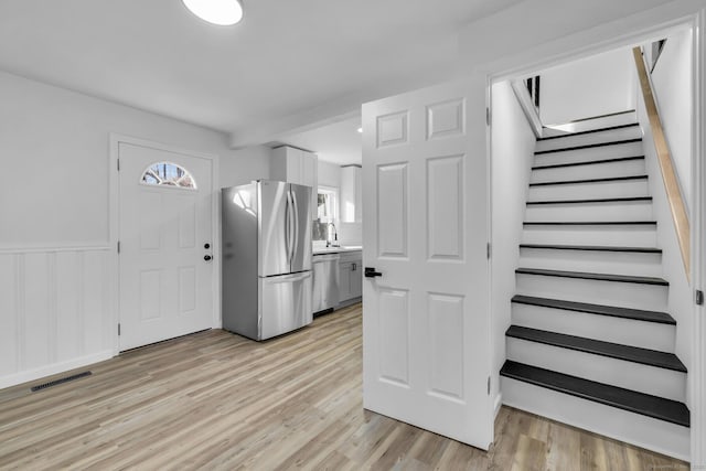 interior space with stainless steel appliances, white cabinetry, and light hardwood / wood-style flooring