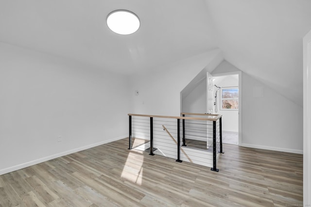 additional living space with lofted ceiling and light wood-type flooring