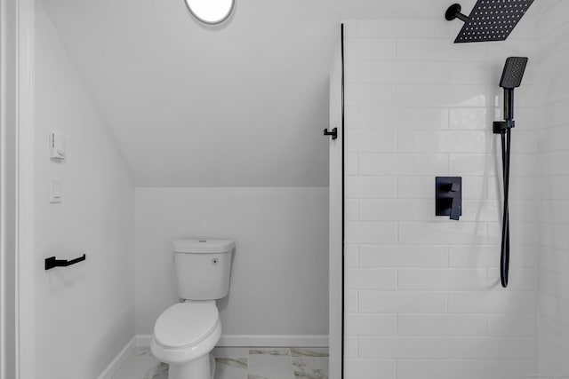 bathroom with toilet, vaulted ceiling, and a tile shower