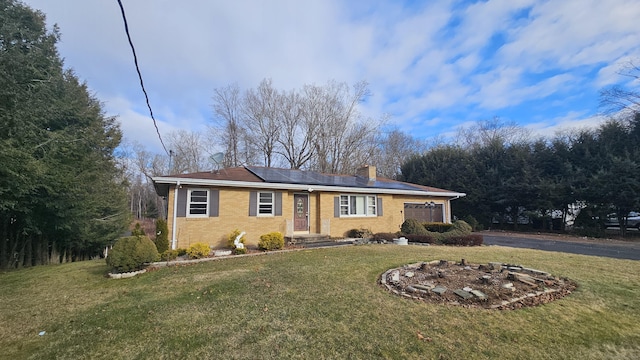 ranch-style house with a front yard and solar panels