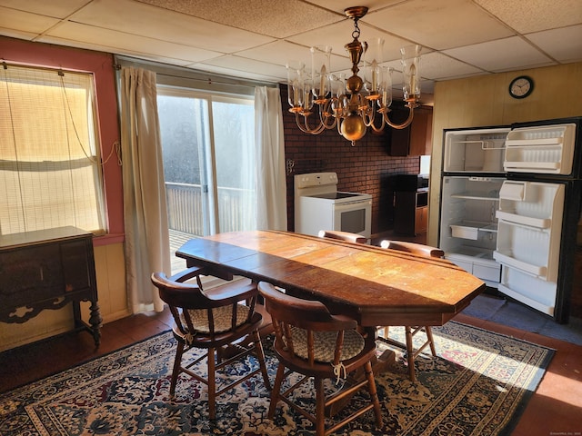 dining space with a paneled ceiling and a chandelier