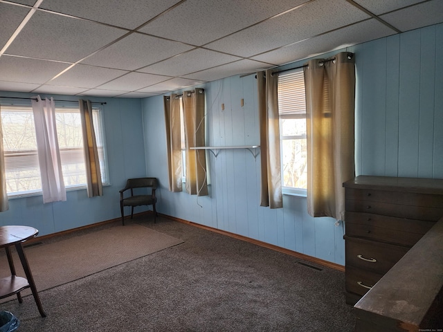 unfurnished room featuring a drop ceiling and carpet