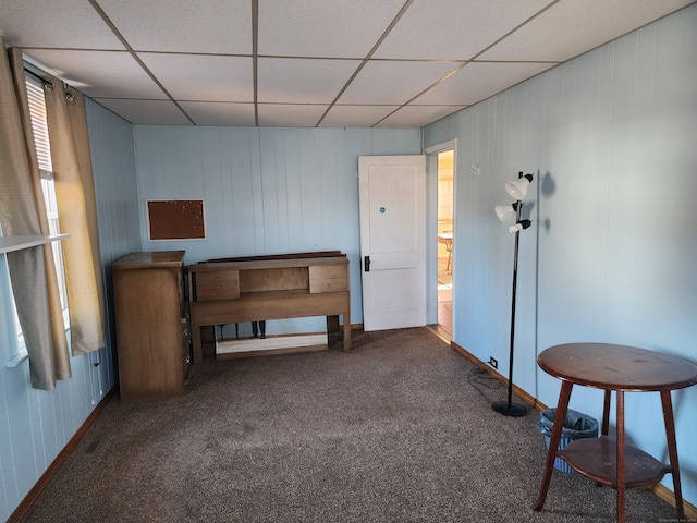 miscellaneous room featuring a paneled ceiling and dark carpet