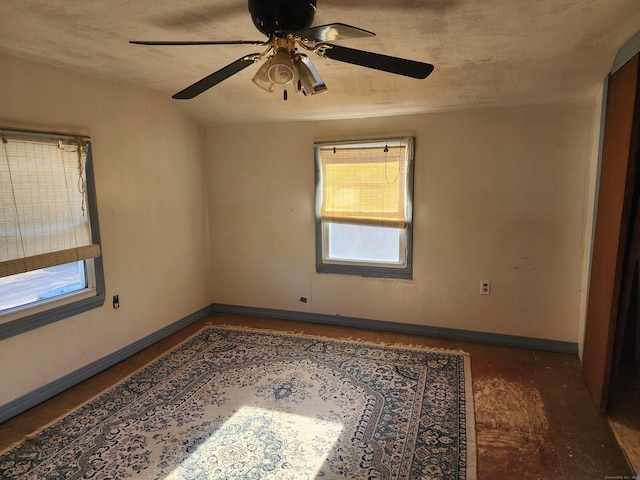 unfurnished room with a textured ceiling, ceiling fan, and vaulted ceiling