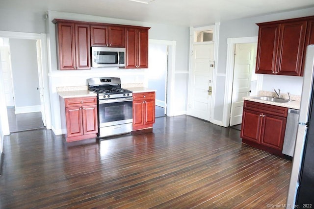 kitchen featuring dark hardwood / wood-style flooring, stainless steel range with gas cooktop, and sink