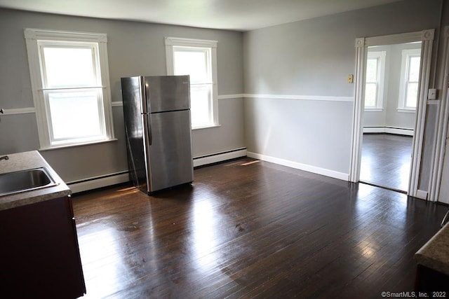 kitchen with a baseboard radiator, stainless steel refrigerator, and a wealth of natural light