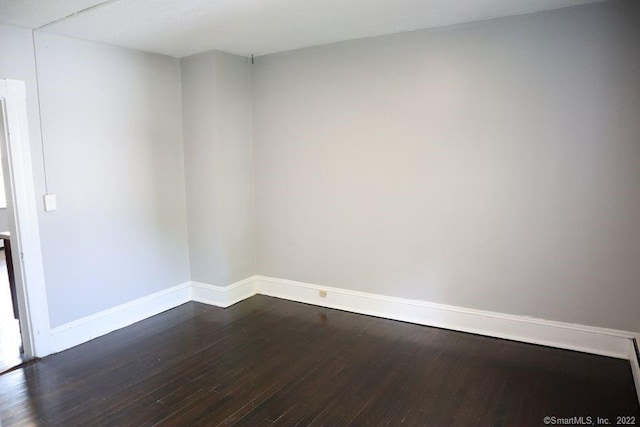 spare room with dark hardwood / wood-style flooring