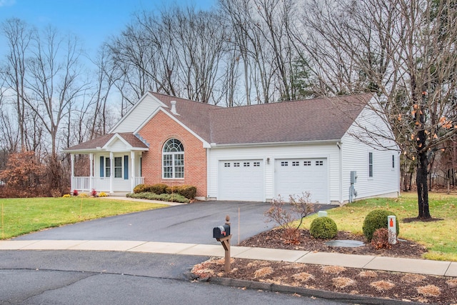 view of front of house with a garage, a front lawn, and covered porch