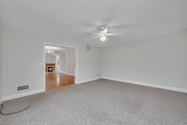 empty room featuring a textured ceiling, ceiling fan, and carpet floors