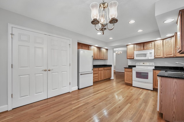 kitchen with decorative light fixtures, sink, white appliances, light wood-type flooring, and a chandelier