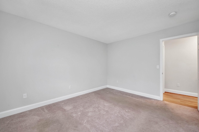 unfurnished room featuring a textured ceiling and carpet