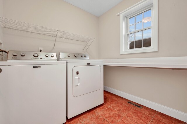 laundry room with washer and dryer and light tile patterned floors