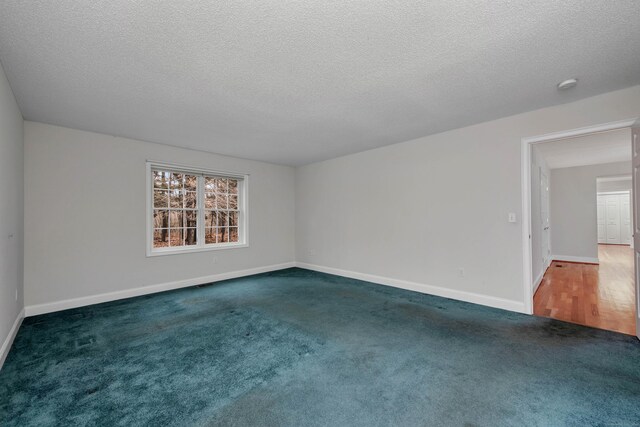 carpeted spare room featuring a textured ceiling