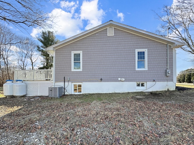 view of home's exterior with central AC and a deck