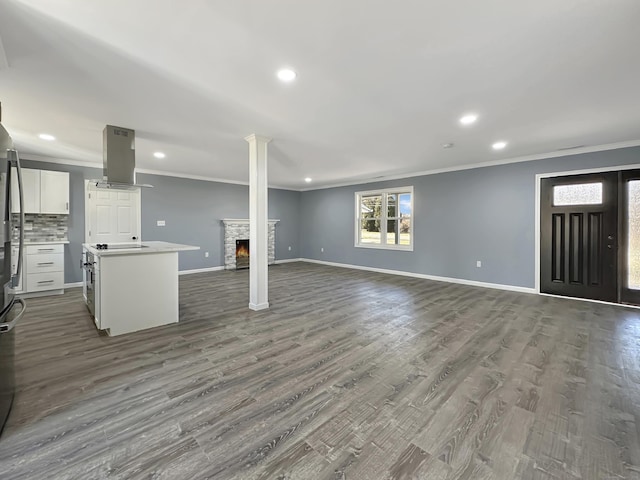 interior space featuring a fireplace, ornamental molding, and wood-type flooring