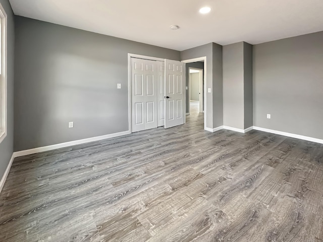 unfurnished bedroom with hardwood / wood-style flooring and a closet