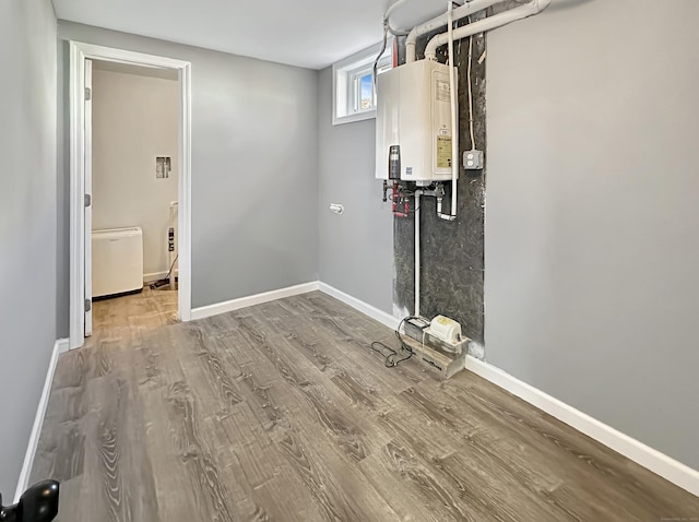 laundry room featuring tankless water heater and hardwood / wood-style floors