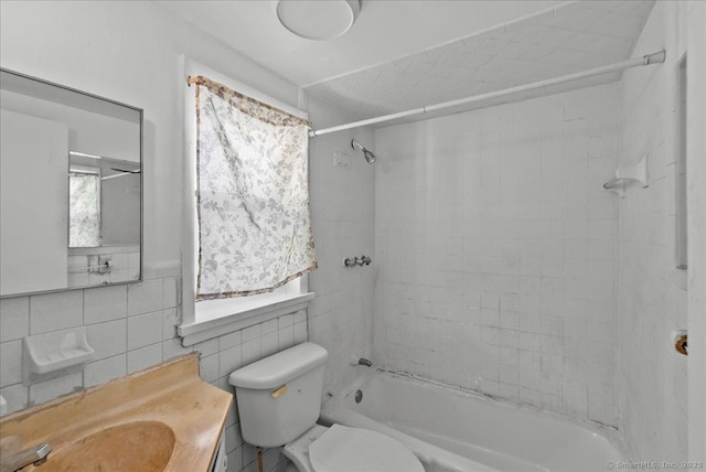 full bathroom featuring vanity, toilet, tile walls, and tiled shower / bath combo