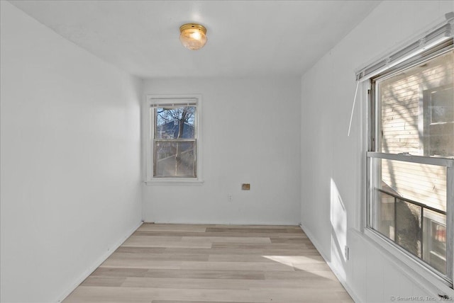 unfurnished room featuring a healthy amount of sunlight and light wood-type flooring