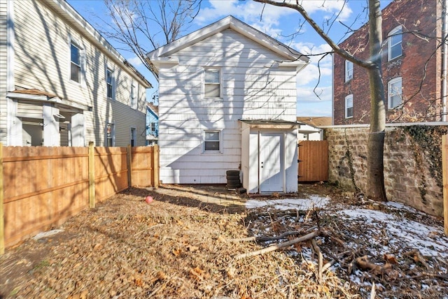 back of house featuring a storage shed