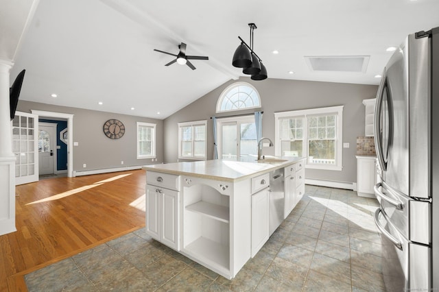 kitchen featuring sink, stainless steel appliances, a baseboard heating unit, a center island with sink, and white cabinets