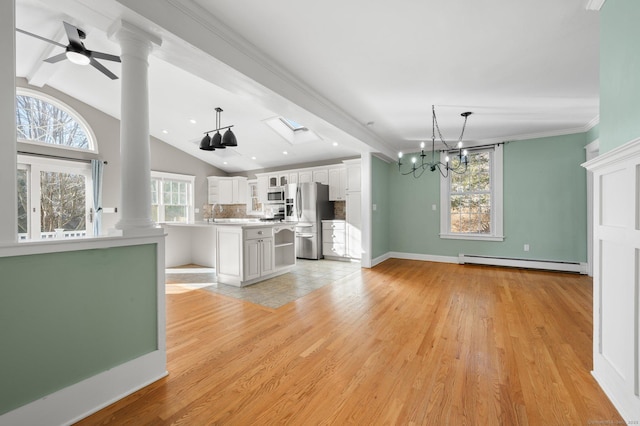 kitchen with ceiling fan with notable chandelier, stainless steel appliances, baseboard heating, white cabinetry, and plenty of natural light