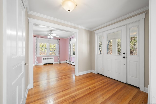 entrance foyer with ceiling fan, light wood-type flooring, ornamental molding, a baseboard radiator, and radiator heating unit