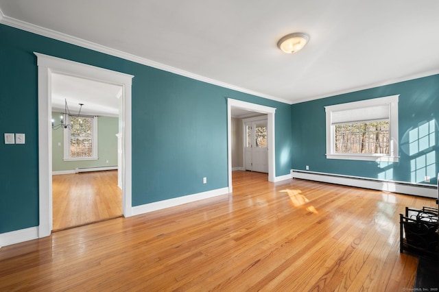 empty room featuring hardwood / wood-style flooring, a notable chandelier, ornamental molding, and a baseboard heating unit