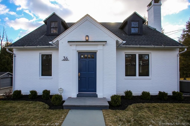 view of front of house with a front lawn and cooling unit