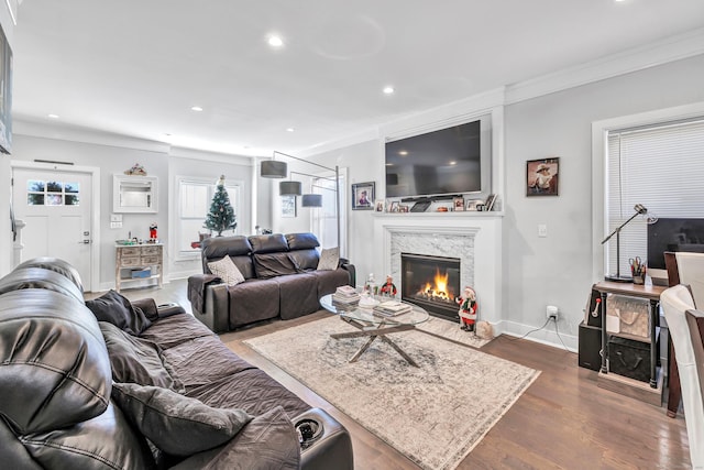 living room featuring crown molding, dark hardwood / wood-style flooring, and a fireplace