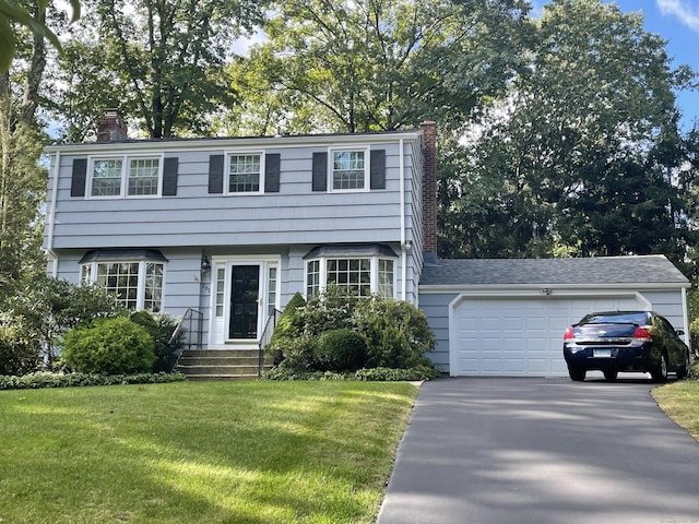 view of front of house with a garage and a front lawn