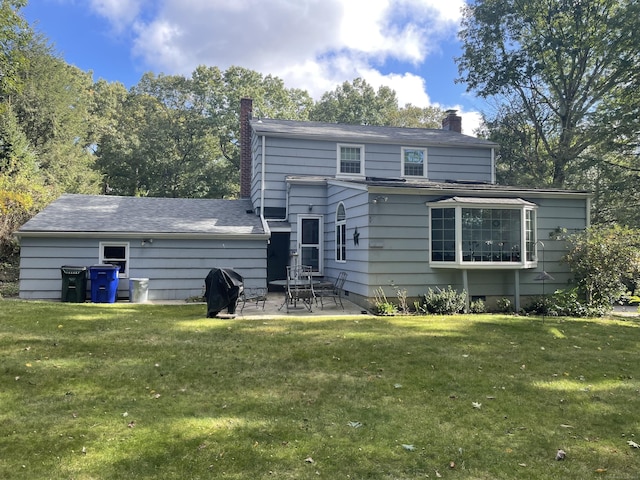 rear view of house with a lawn and a patio