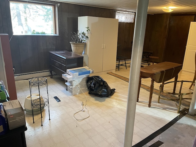 basement with a baseboard radiator and wood walls