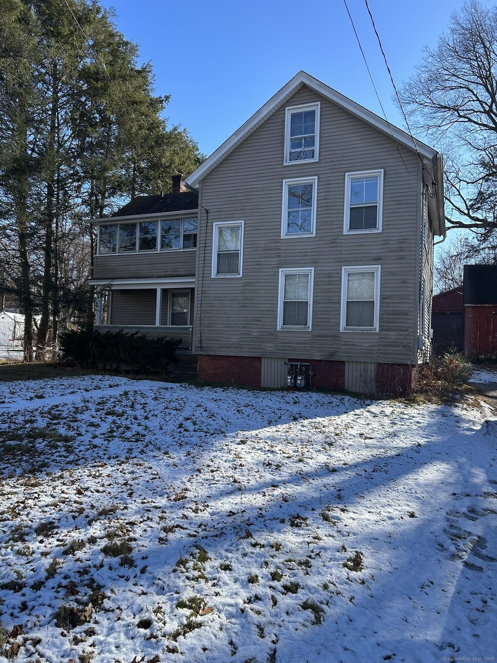 snow covered property featuring a chimney