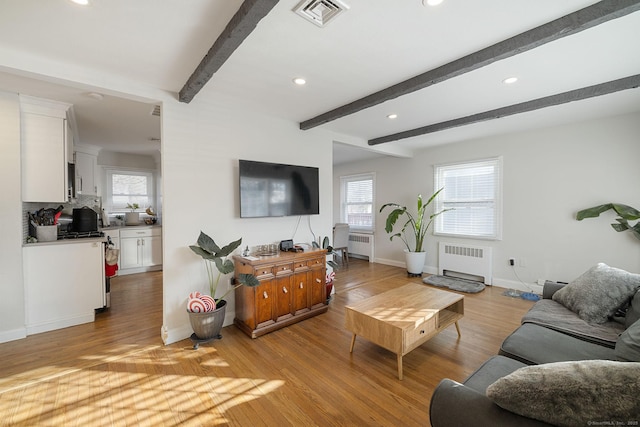 living room featuring beam ceiling, light wood-type flooring, and radiator