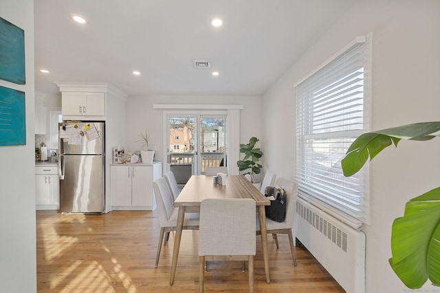 dining room featuring radiator and light hardwood / wood-style flooring