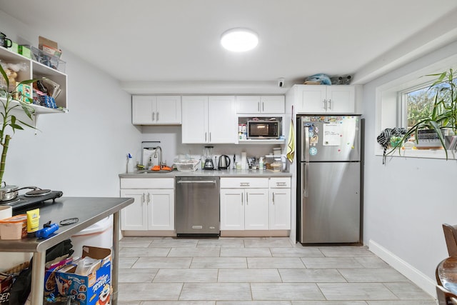 kitchen featuring stainless steel appliances, white cabinetry, and sink