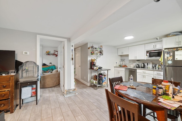 interior space with light hardwood / wood-style flooring, white cabinets, and stainless steel appliances