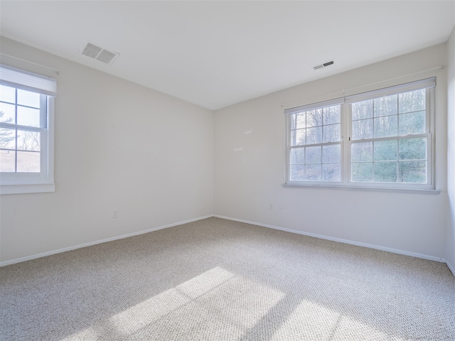 empty room with plenty of natural light and carpet