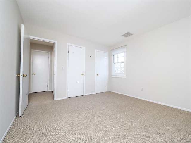 unfurnished bedroom featuring light carpet