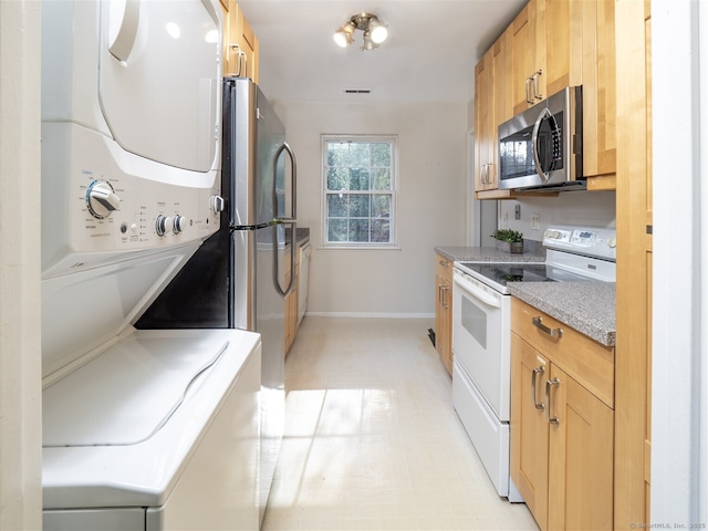 kitchen with stacked washer and dryer and white range with electric cooktop