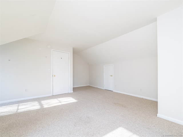 bonus room featuring light colored carpet and vaulted ceiling