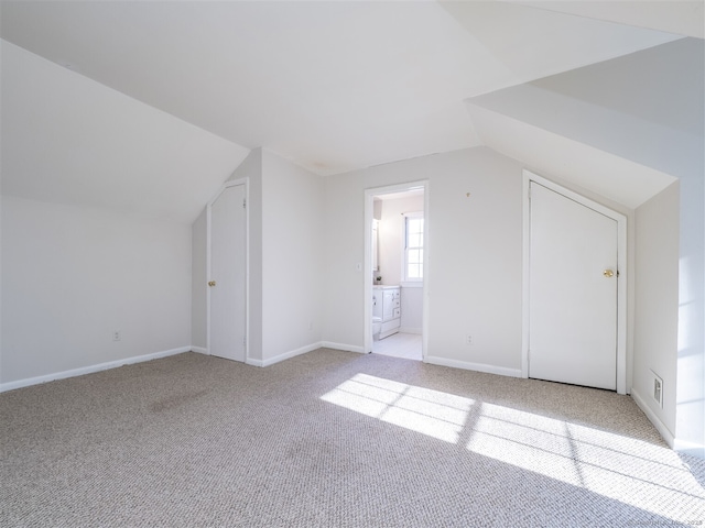 bonus room featuring lofted ceiling and light carpet