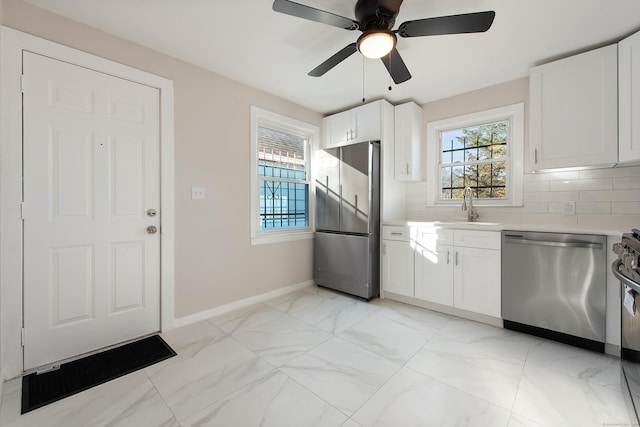 kitchen featuring white cabinetry, sink, ceiling fan, decorative backsplash, and appliances with stainless steel finishes