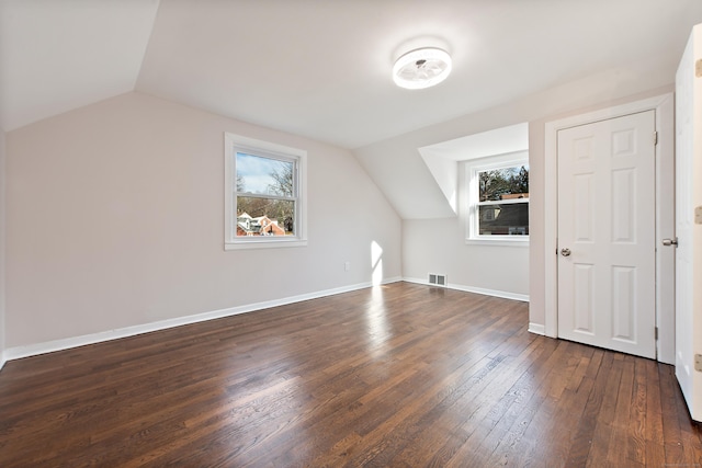 additional living space featuring dark hardwood / wood-style floors and lofted ceiling