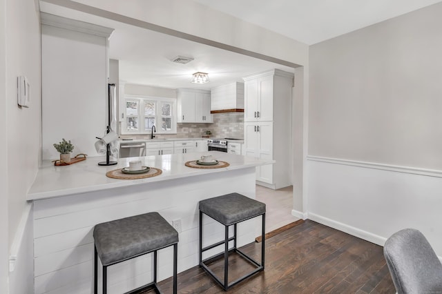 kitchen featuring a breakfast bar, white cabinets, sink, tasteful backsplash, and stainless steel appliances